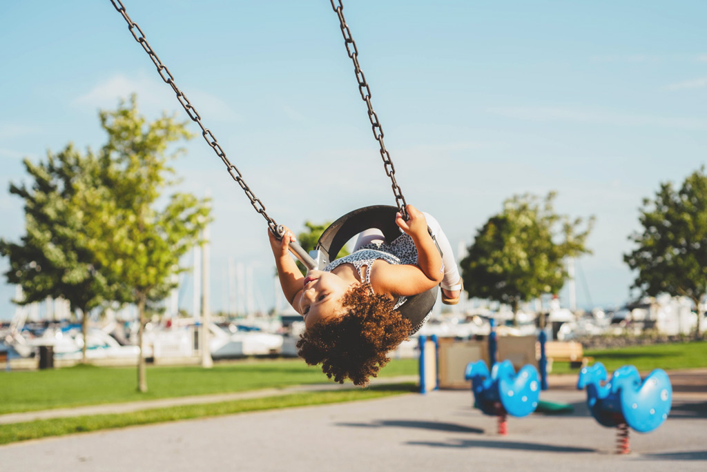 A child enjoying the swings on a summer day